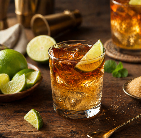 Dark 'n' Stormy im Glas mit Eiswürfeln und Limette – Rum und Ginger Beer Cocktail
