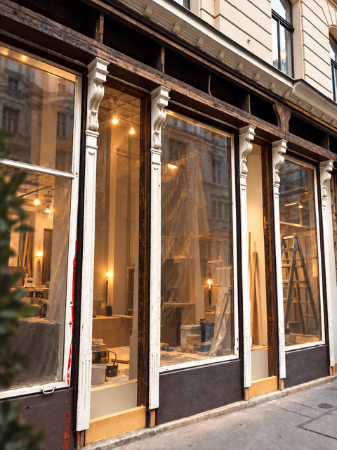 Historische Ladenfront in Wien während des Umbaus zum neuen Rumzentrum-Shop, mit beleuchtetem Innenraum und sichtbaren Renovierungsarbeiten.