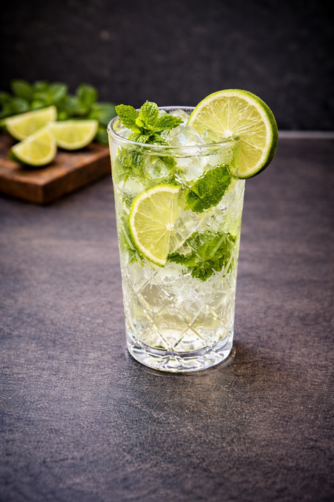 Frischer Mojito Cocktail mit Limette, Minze und Crushed Ice im Glas – erfrischendes Sommergetränk auf dunklem Hintergrund, ideal für Bar, Restaurant oder Event