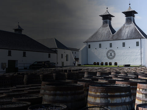 Ardbeg Distillery mit Holzfässern im Vordergrund